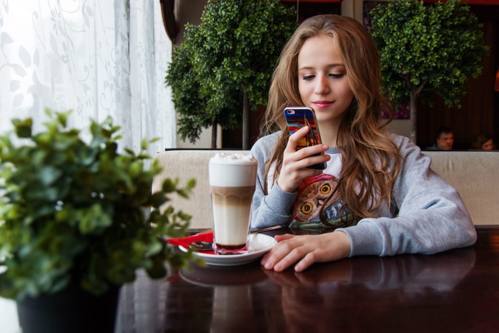 Young woman looking at her phone sitting in a cafe