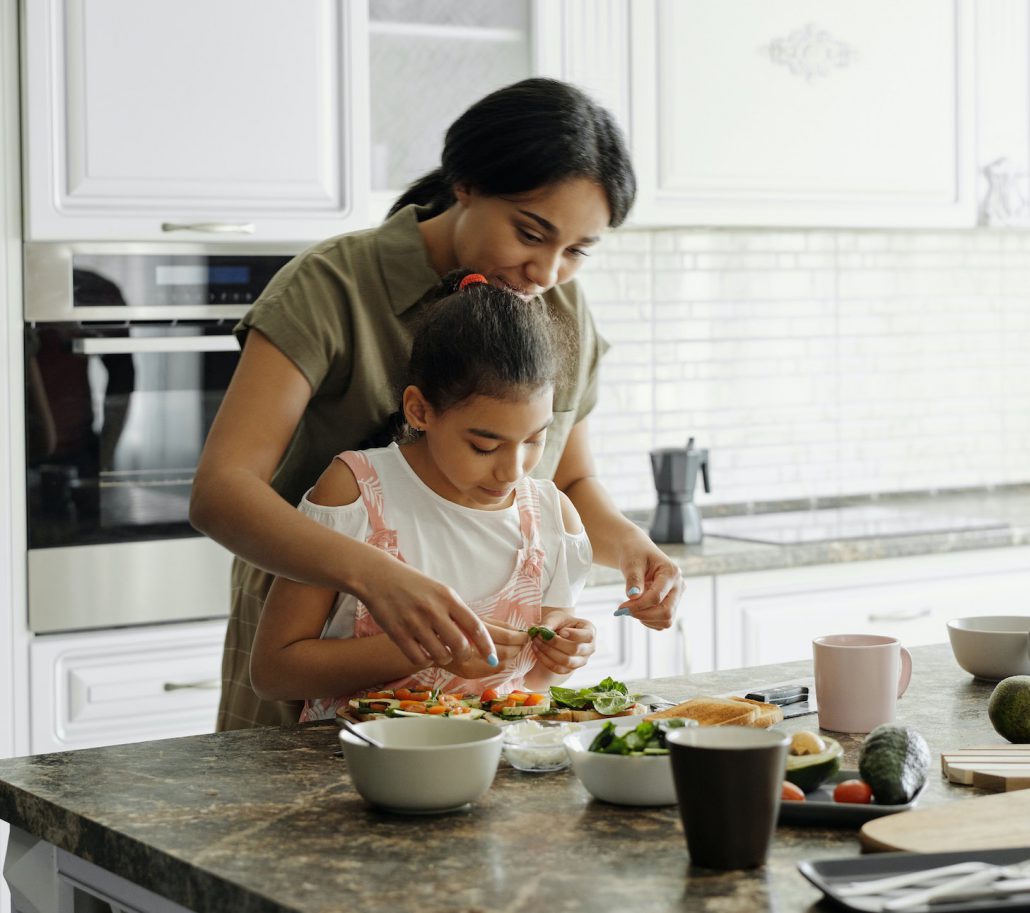 Hispanic mother and daughter cooking