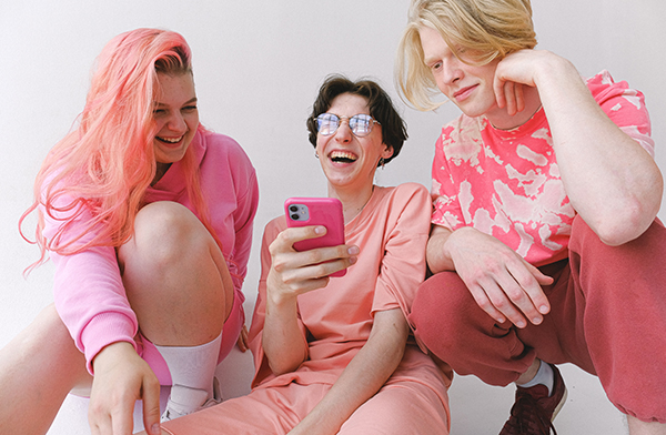 Group of three young women laughing in pink