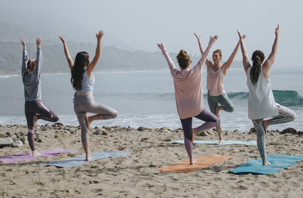 Crowd of people doing yoga on the beach