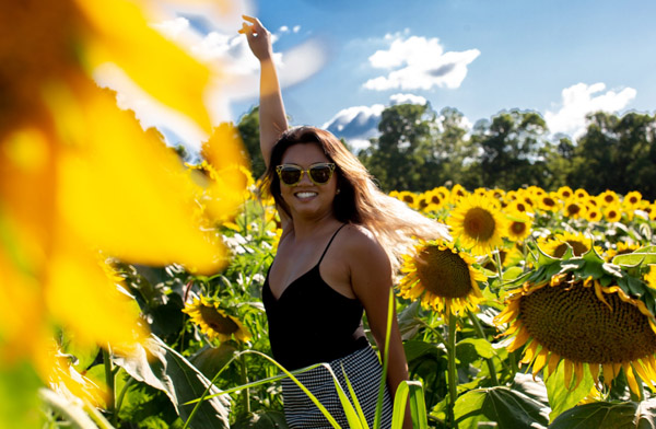 Young Asian woman in field of sunflowers