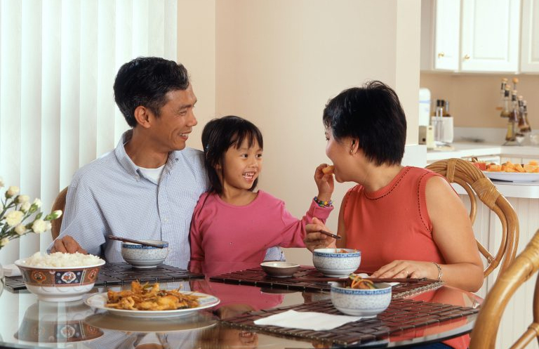 Asian parents and daughter eating a meal