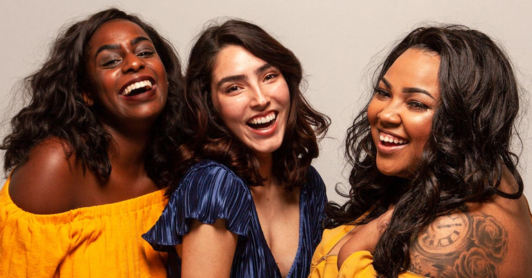 multicultural trio of women smiling and laughing