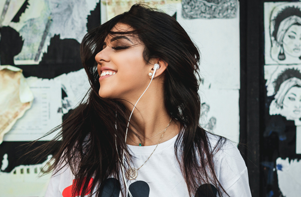 Hispanic woman smiling and listening to music