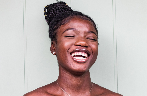 Black woman with hair up smiling