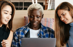 Group of multicultural women looking at a laptop