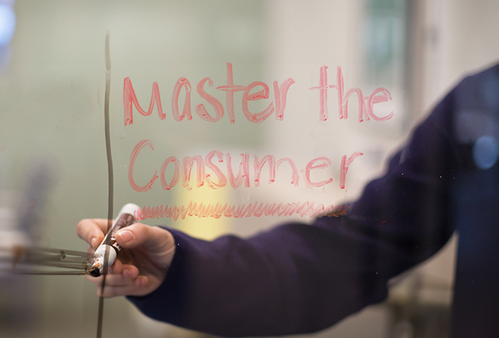 Master the Consumer written in red on glass