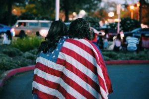 Two women wrapped in an American flag