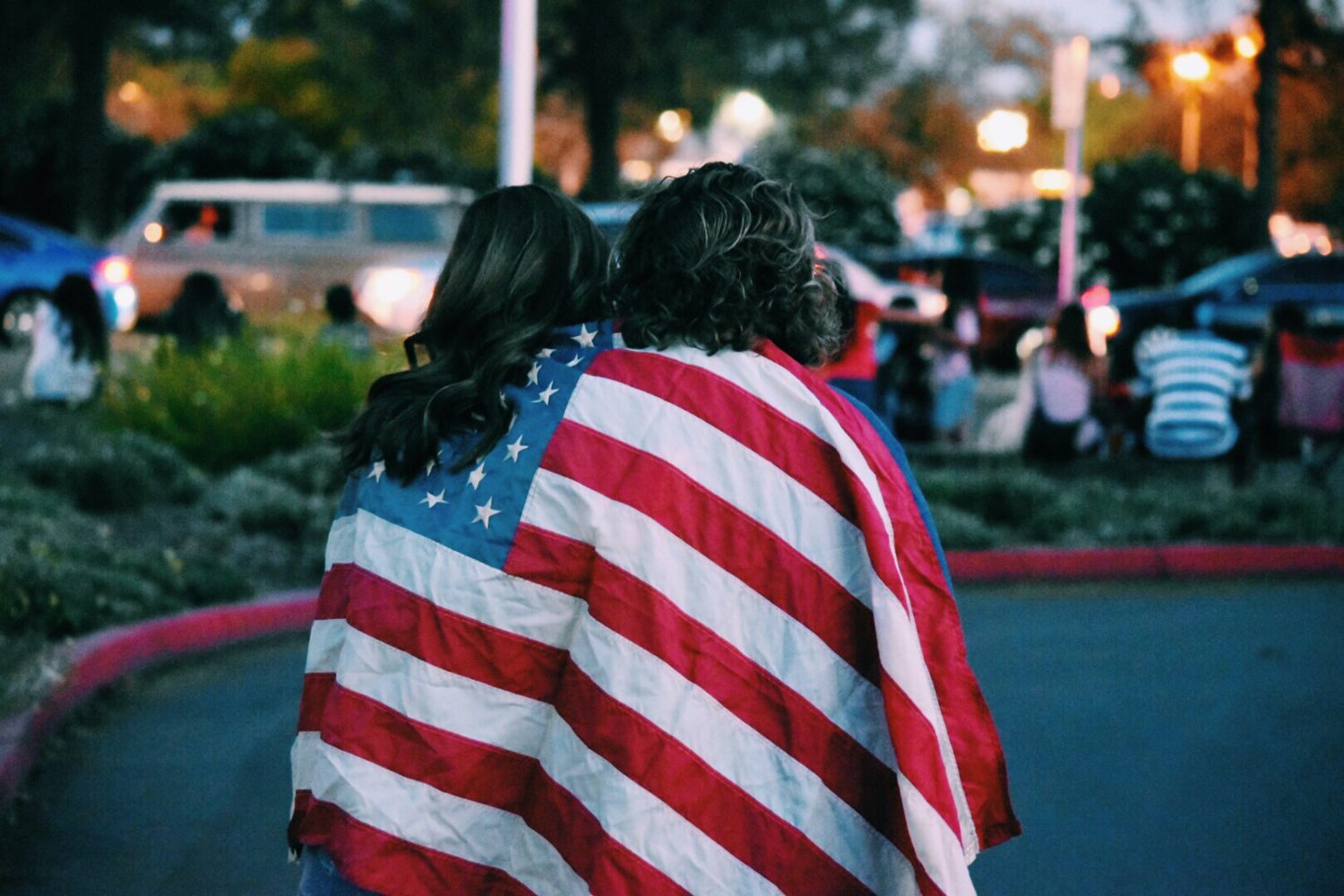 Two women wrapped in an American flag