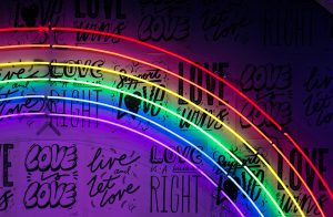 LGBTQ+ neon pride rainbow sign glowing on a purple wall