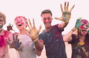 Four happy teenagers participating in a color run