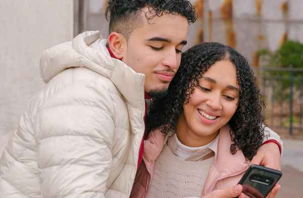 Young Hispanic couple looking at a cell phone together