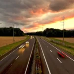An empty road at sunset with trees and fields in the distance