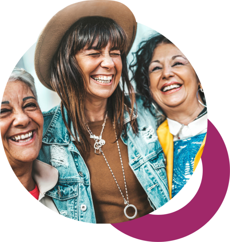 Three Gen Z women in hats laughing and embracing