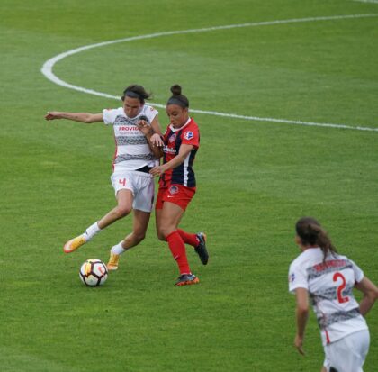 women on playing a game on a soccer field