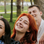 Group of Gen Z kids smiling at and taking a photo
