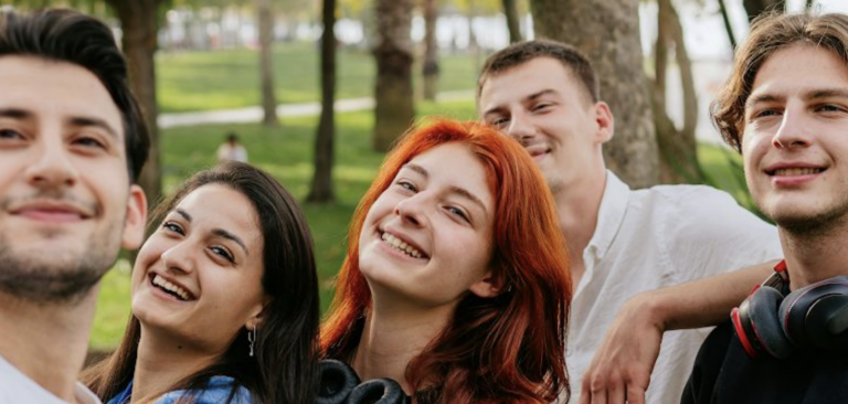 Group of Gen Z kids smiling at and taking a photo