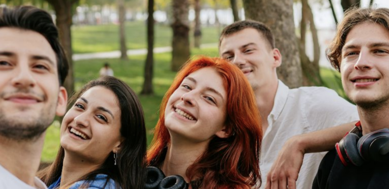Group of Gen Z kids smiling at and taking a photo