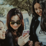 Group of Gen Z girls smiling at their phone