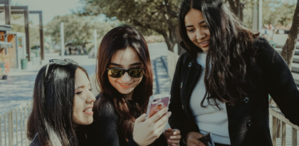 Group of Gen Z girls smiling at their phone