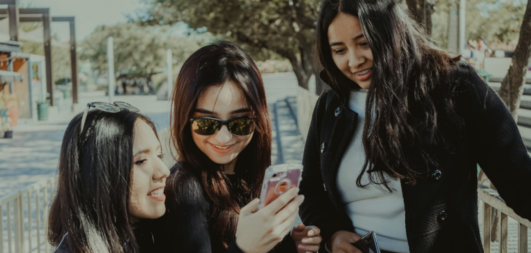 Group of Gen Z girls smiling at their phone